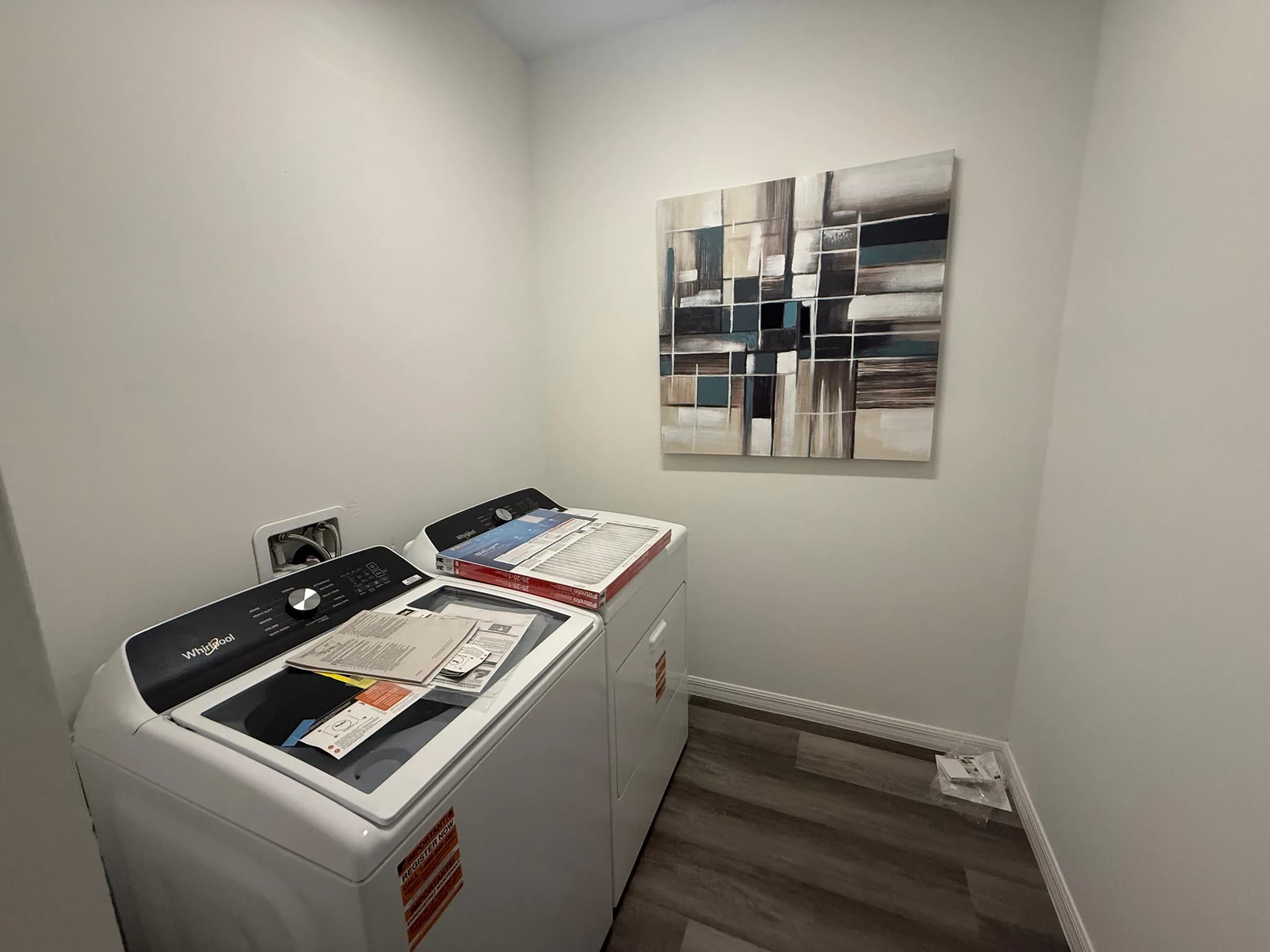 Finished laundry room with installed appliances and storage